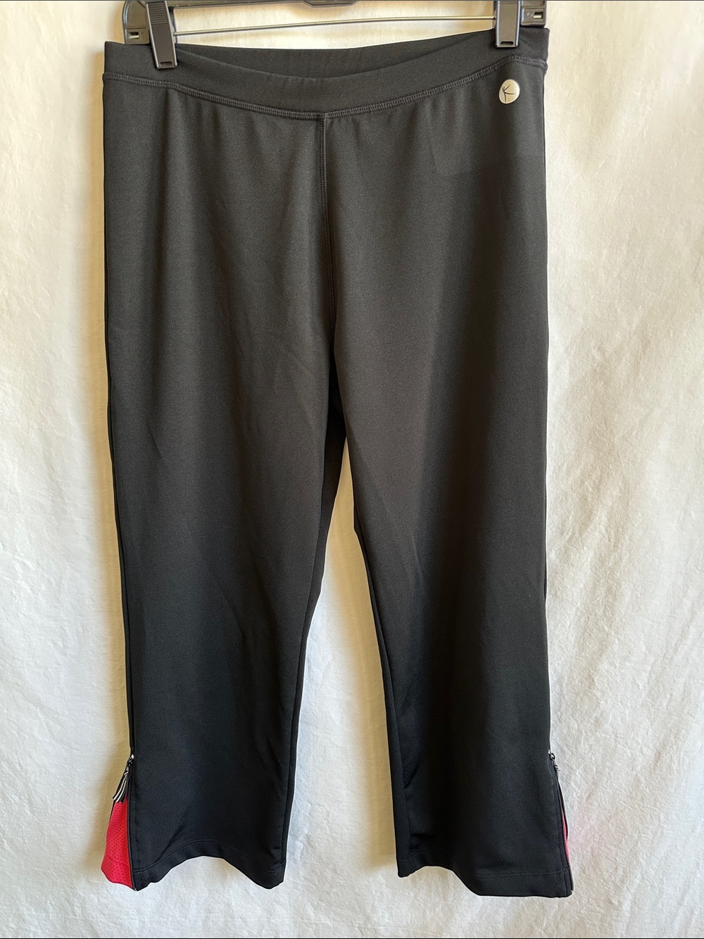 Danskin Now black athletic pants with peek-a-boo orange color pop, size M